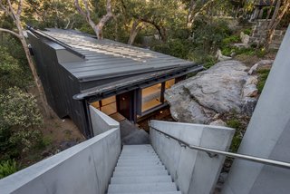 An Arresting Australian Abode by Glenn Murcutt Needs a Buyer - Photo 1 of 8 - The house sits on a steep site and was positioned below a sandstone crop so as to be concealed from the street. The approach to the house is via a suspended, concrete staircase.
