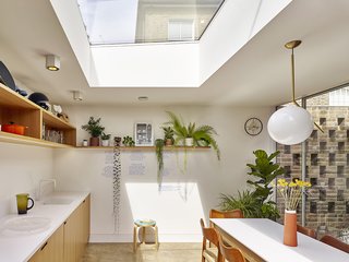 In the combined kitchen and dining room, a skylight lets in lots of sunlight, and the table overlooks the courtyard.