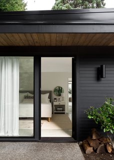 A 1957 Midcentury in Seattle Receives a Striking Makeover - Photo 10 of 16 - Generous overhangs and period lighting speak to the home's original era, while sliding glass doors add a modern touch and create easy outdoor access.