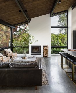 A 1957 Midcentury in Seattle Receives a Striking Makeover - Photo 5 of 16 - A new double-height fireplace is now the focal point of the spacious living room. It effortlessly underscores the room's graceful proportions.