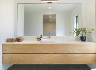 Four-star plumbing fittings, a 10,000-liter tank for rainwater harvesting, and an Eco Hot Water Heat Pump from Sanden promote water and energy savings throughout the home.