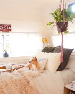 In the bed nook, a pull-out sofa was swapped out for a mattress, which is decked out in neutral and textural linens, as well as a built-in nightstand.