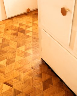 To give the 40-square-foot floor a stylish look, peel-and-stick tile was traded for a mosaic of three-inch wood triangles cut from reclaimed Cypress.