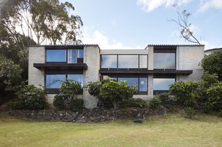 A back view of the house reveals its glass facade and perch on the hillside overlooking East Honolulu.