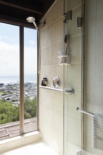 A shower with floor-to-ceiling glazing fosters indoor/outdoor flow.