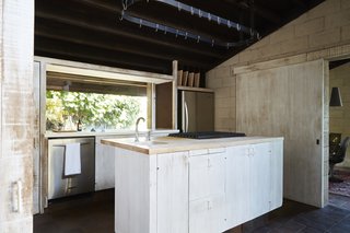In the kitchen, rough-cut wood was treated to give it a bleached look that contrasts with the dark ceiling.