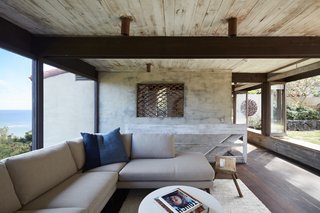 The living room is a cozy spot nestled between the expansive picture window and open doors that lead to the courtyard.