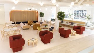 Deep red upholstered chairs from Missana are offset by a blush background in the spacious common room.
