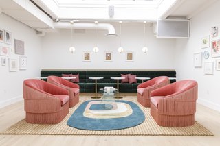 A bespoke rug from French creator Toulemonde Bochart sits nicely with the rose Munna's Fringes armchairs. This room also features a forest green custom sofa from voila! Creative Studio, as well as ceiling pendants by Neptune Glassworks.