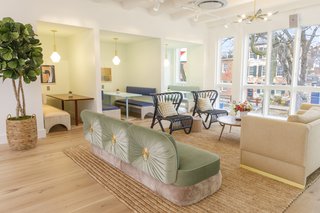 A mint couch from Cristina Celestino complements rattan chairs from 1st Dibs and the Cedar & Moss pendants over the booths.