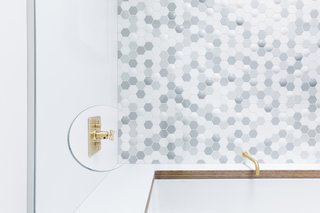 A thoughtful cut-out in the glass enclosure allows people to reach for the faucet without getting hit with the shower spray. "It's a bit of a signature thing for us," says Horner.