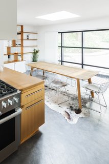 The wall of windows is original, while the floor received new concrete. Horner also specified a new stove and hood, as well as a new backsplash in large, textured field tile from The Surface Store in Portland.