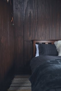 A queen-size bed in the bedroom features cozy, simple linens.