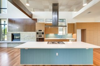 The kitchen features an expansive, quartz-topped island and Bosch appliances.