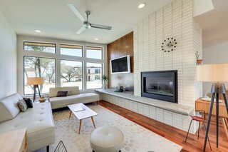 The open-concept living room features a fireplace clad in white brick.