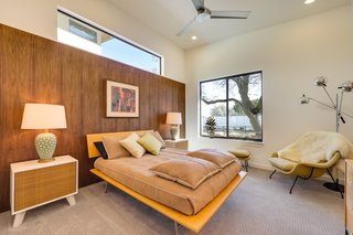 A wood-paneled wall cozies up the bedroom. The entire home was staged by Modern Redux, a local shop "devoted to the pursuit, rehabilitation, and reintroduction of fine 20th-century modern furnishings and decorative arts to a contemporary audience."