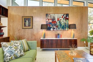 A wood-paneled feature wall is topped with trapezoid-shaped, clerestory windows.