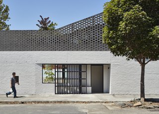 A view of the new eastern-facing front door. "At the second level, brickwork gradually opens up to become a perforated brick screen for the roof top deck," explain the architects.