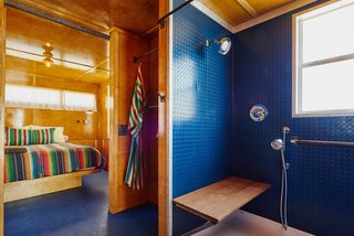 Inside this trailer, the blue shower and floor contrast warmly with the birch interior.