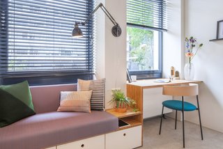 A simple desk area merges with a built-in sofa, which includes storage beneath it. The wood components in the units are bamboo, chosen for its durability and warmth.