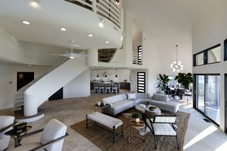 The main floor has an open living, dining, and kitchen area with unobstructed views since support beams were unnecessary for the domed structure. The floors are concrete with a decorative finish.