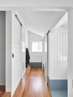 A new bathroom wing upstairs hosts private toilet and shower rooms, as well as separate spots for bathing and accessing the sink. It further pushes the theme of thoughtful material connections, using tile instead of concrete to contrast with the wood.