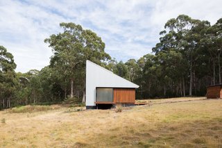 The 301-square-foot cabin is situated on 99 acres on Bruny Island, an island off the coast of Tasmania. For the exterior, the architects have chosen materials that "comply with the Bushfire Attack Level of 19," they explain, including bushfire resistant wood and zincalume metal. The cabin collects its own rainwater—storage tanks are underground for an uncluttered look—and the roof sports solar panels.