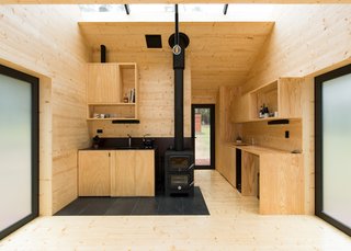 A Nectre Bakers oven provides sharply defined contrast at the kitchen, and also supplies heat in colder temperatures. The oven is used for baking, as well as space-heating. The translucent doors on both sides open to east and west-facing decks to capture morning and evening sun.