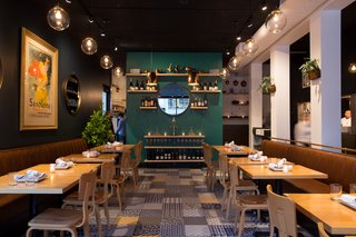 The rest of the bistro's palette, from the camel leather banquettes to the aquamarine accent wall, was chosen to complement the beautiful floor tile.