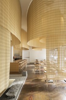 Kuma and his team suspended large swaths of bamboo screens from the ceiling. "Instead of hanging it with the filaments arranged horizontally, we turned the bamboo screens ninety-degrees so that the strands were oriented vertically," architect Balazs Bognar told Eater PDX. "It’s an age-old material, but used in a new way."