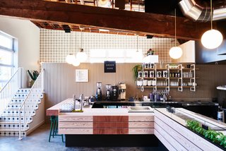 The vegan pizza and ice cream bar features a reclaimed wood counter, dark green Muuto Nerd stools, and Clé tile on the stair risers.
