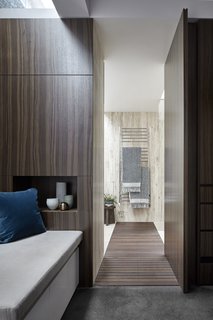 The view into the en-suite bathroom. The repeated use of travertine and timber creates consistency with the rest of the house.