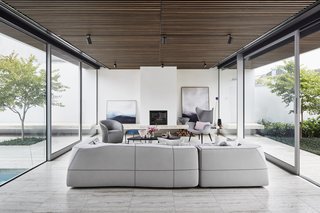 The extensive glass walls are composed of sliding panels in order to create complete indoor/outdoor flow with the courtyards on either side. "The two main courtyards are oriented to maximize morning sunlight into the home and permit cross ventilation," note the architects.