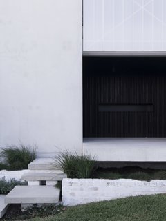 Blackened, recycled wood slats define the front entry alcove. "The design of House A was originally intended to challenge the status quo of oversized and low-quality housing in Western Australia," say the architects.