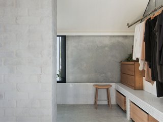 According to the architects, the firm "merged spaces and volumes to achieve simultaneous privacy and openness without the need for doors and walls." An open closet adjoins the upper level ensuite bathroom and looks neat and tidy with detailed finishes that are consistent with the rest of the house.