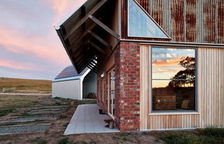 The exterior combines recycled brick, radial sawn timber, and galvanized roof sheeting. "Materials were selected to meet the clients’ brief that the house fit within the cognitive idea of an old shed," explain the architects.