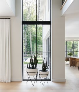 A two-story window floods the inside with light. The planters are from West Elm.
