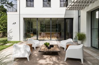 A limestone terrace beckons off the main living areas. The white outdoor chairs are from IKEA.