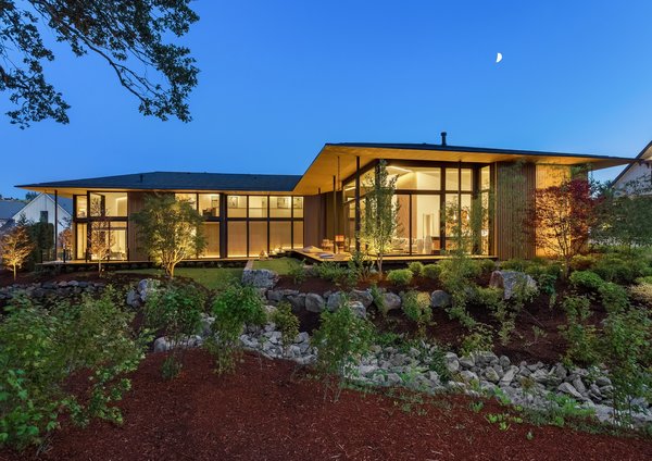 Kengo Kuma designed Suteki House to keep a low profile "under a single, beautiful, and elegant horizontal roof." The L-shaped house hugs the slope of the lot, and the expansive use of glass maintains the interior connection to the exterior on both levels.
