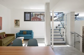 The interior includes furnishings from Nirvana Home, Article, and Restoration Hardware. The open staircase with clear balustrades keeps sight-lines clear and uncluttered.