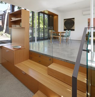 The kitchen was sunk down a few steps to better define it from the rest of the living spaces. Built-in Douglas Fir cabinetry, courtesy of Built Work Design, maximizes storage. The custom Douglas Fir table is by ZZ Contracting.