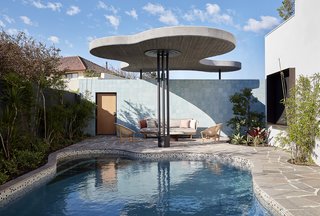 The architects brought the undulating lines outside with the pool's shape and overhead awning.