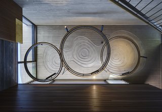 The custom-designed pendant lights over the stairs echo the undulating recesses in the concrete ceiling. That sinuous motif is repeated in various ways throughout the project.