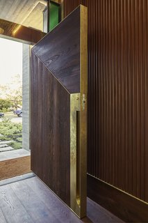At the custom front door, textured wood is accented with un-lacquered brass to encourage patina with use.