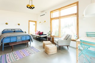 Seen here, Tu Casa is decked out in stylish, second-hand finds, bright pink pillows from Collectivo, and lighting from Schoolhouse Electric, including the Isaac and Satellite Sconces.