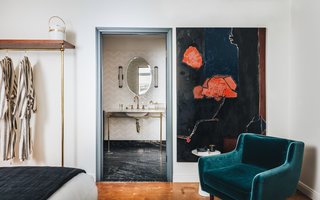 Large-scale artwork makes a statement throughout the hotel, and the collection includes paintings by Parquet Courts singer Andrew Savage. The bathroom juxtaposes chevron wall tile with a traditionally appointed sink and luxe black stone floor.