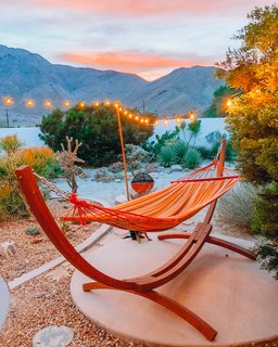 A striped hammock is perfectly placed for relaxing and taking in the sunset.