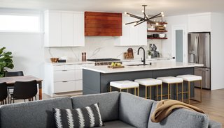 A new pantry with a frosted glass door, to the left of the fridge, now keeps clutter out of sight. The island is painted in Sherwin Williams "Iron Ore."