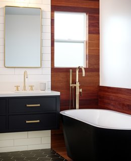"The tub was an important element for the client, so we designed the teak wall and floor element to elevate that tub area since there was not enough space to completely separate it from the rest of the bathroom," said Maggio.
