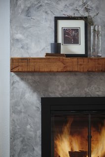 The fireplace received a dark gray venetian plaster finish and salvaged wood mantel.